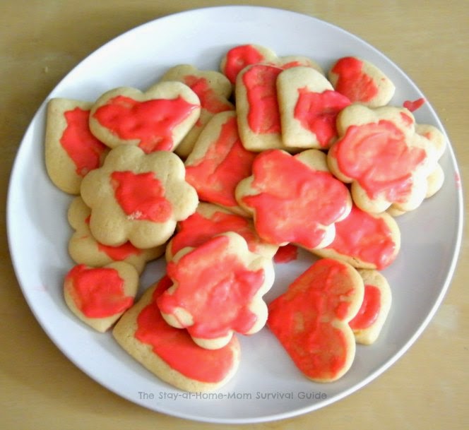 Bake sugar cookies shaped like hearts and flowers to place in homemade Valentine treat bags-simple idea for even the not-so-crafty moms! Idea and recipe shared at The Stay-at-Home-Mom Survival Guide.