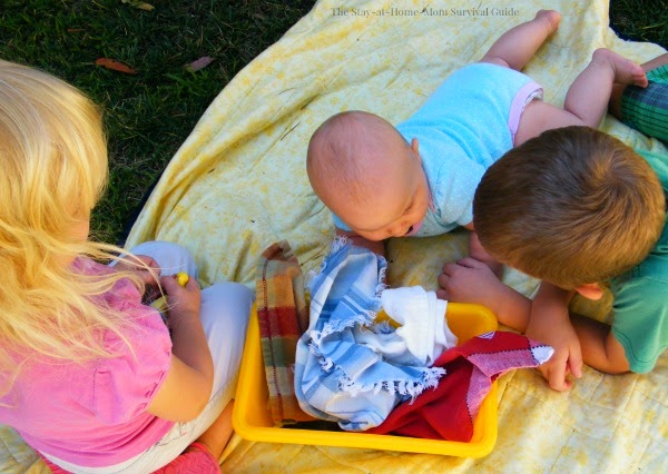 Simple sensory bin for infants. A baby play activity to enhance tummy time and explore fine and gross motor skills in infants.