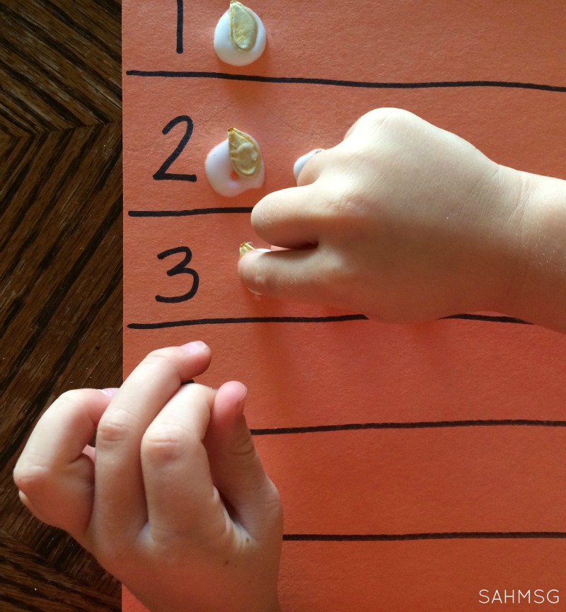 Fine motor work gluing pumpkin seeds for counting and number recognition practice for preschool. Pumpkin or Fall theme activity.