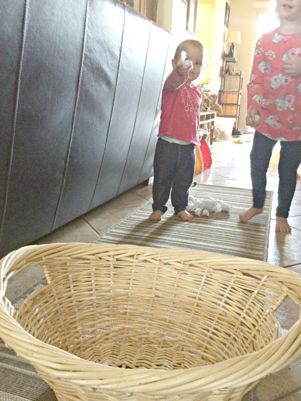 Too cold to play in the snow outside or don't have any snow where you live? Bring the snowball toss indoors for some gross motor fun for babies, toddlers, preschoolers and school age kids. This is so easy to set up with only two supplies. Great for indoor winter fun!