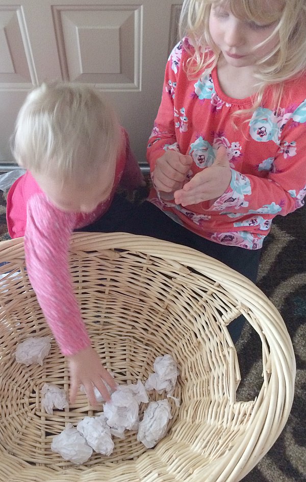 Too cold to play in the snow outside or don't have any snow where you live? Bring the snowball toss indoors for some gross motor fun for babies, toddlers, preschoolers and school age kids. This is so easy to set up with only two supplies. Great for indoor winter fun!