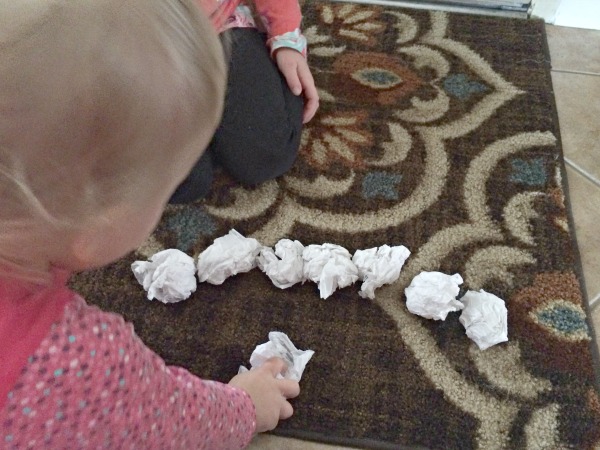 Too cold to play in the snow outside or don't have any snow where you live? Bring the snowball toss indoors for some gross motor fun for babies, toddlers, preschoolers and school age kids. This is so easy to set up with only two supplies. Great for indoor winter fun!