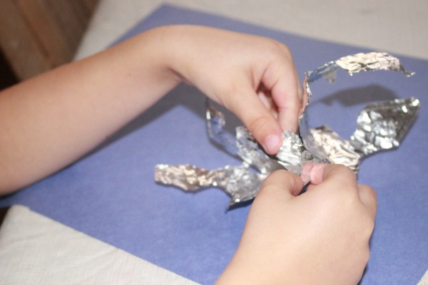 What a fun indoor activity for winter time! Kids can paint foil snowflakes. This simple snowflake foil craft combines cutting, painting and fine motor skills for preschool.
