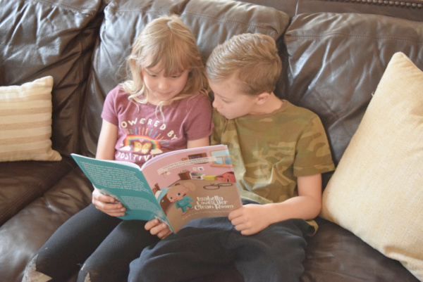 Preschoolers reading the Itty-Bitty Isabella book series to learn how to clean up and other life skills for kids.