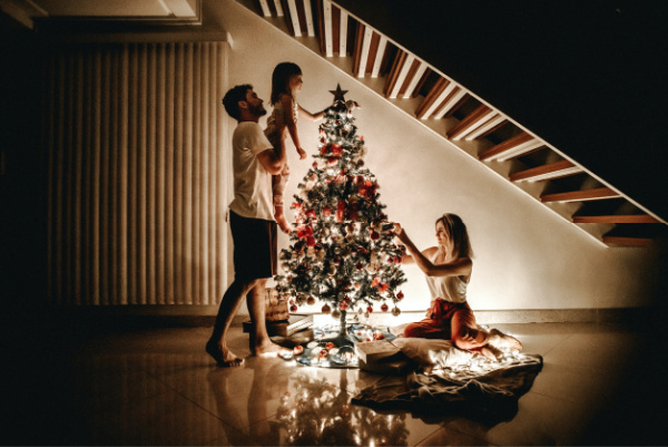 Family decorating the Christmas tree working together to complete holiday preparations.