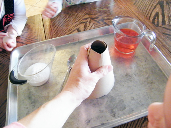 Place the paper cone over the jar containing the baking soda.