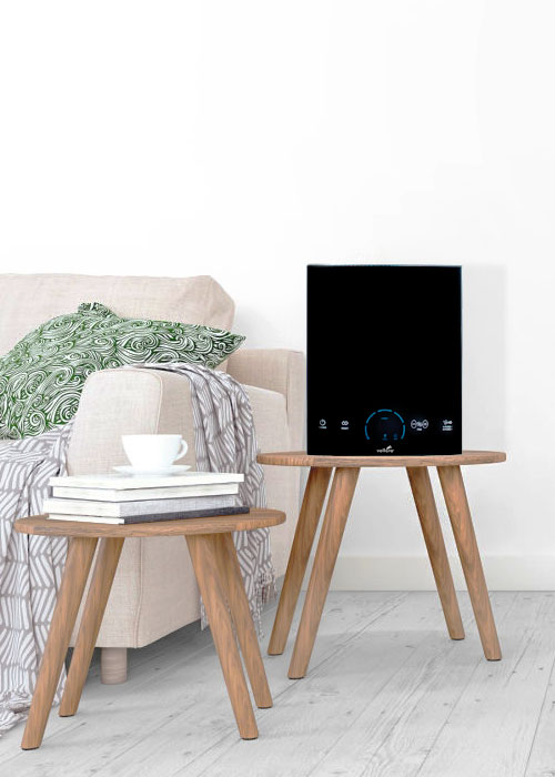 Vollara Air Purifier sitting on an end table near a couch.