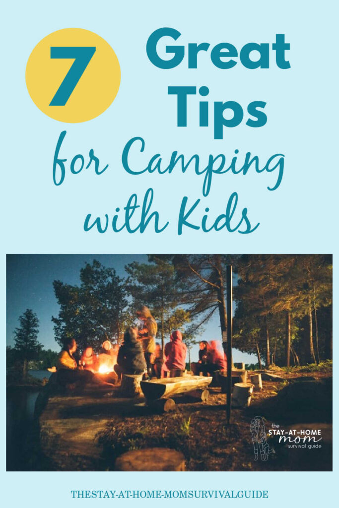 Family sitting around campfire. Text reads 7 great tips for camping with kids.