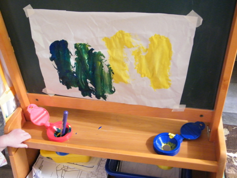 Child's easel with two paint colors to make DIY color wheel color mixing cards.