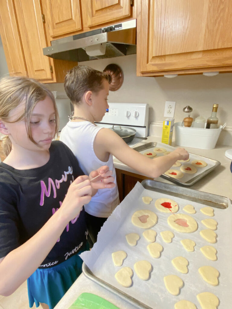 Two kids baking cookies.