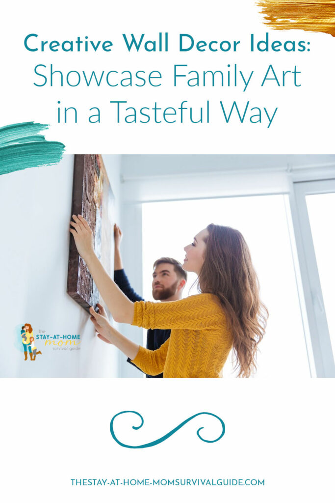 Man and woman hanging a large piece of art on the wall. Text reads creative wall decor ideas: showcase family art in a tasteful way.